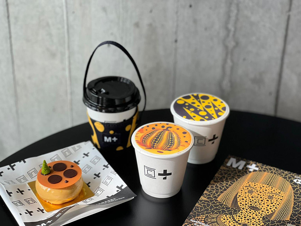 专为M+而设计的草间弥生“艺术打印咖啡”，呈现艺术家标志性的、由橙色及黑色圆点所组成的艺术图案。
