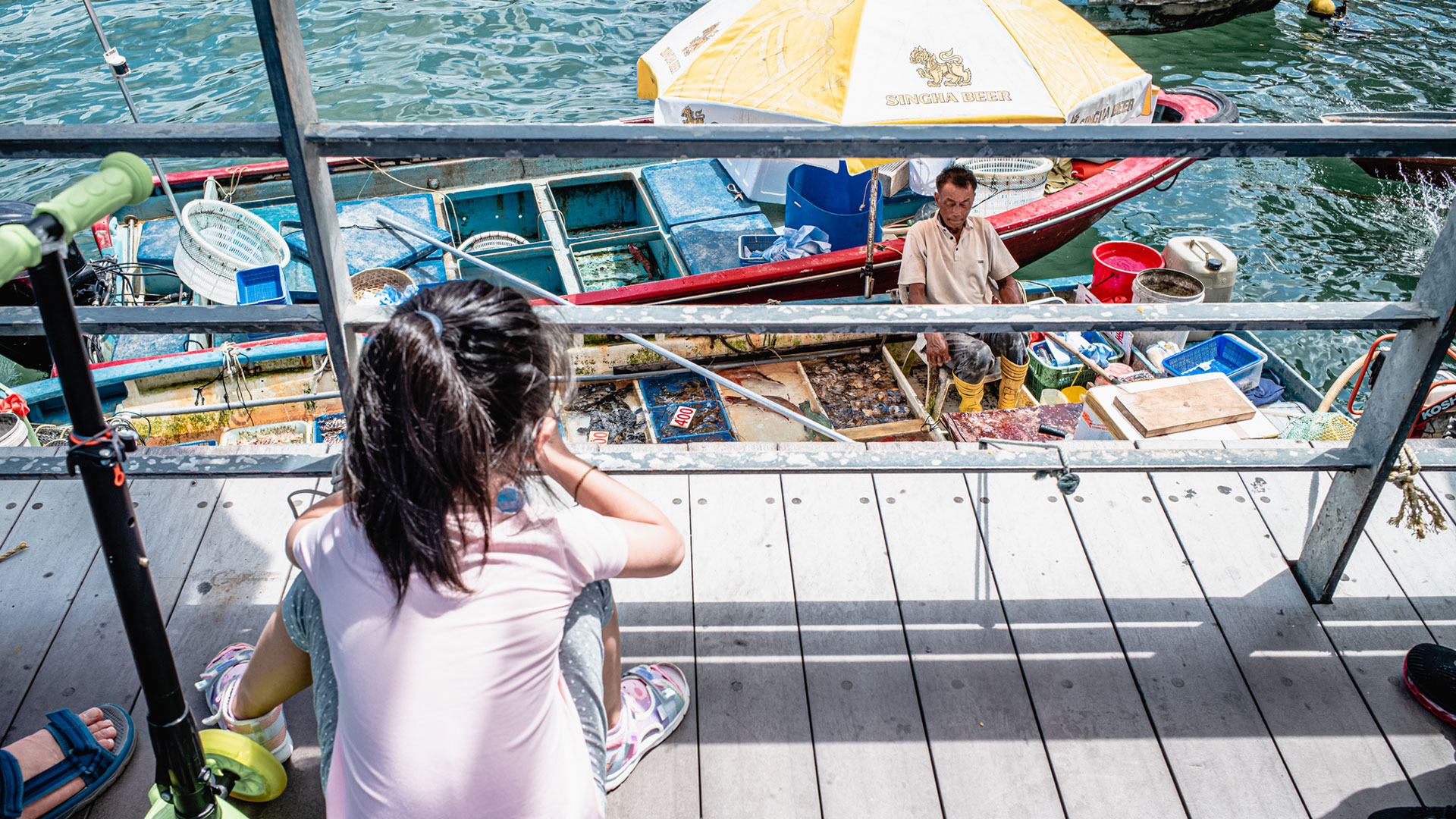 小女孩看着水上摊贩