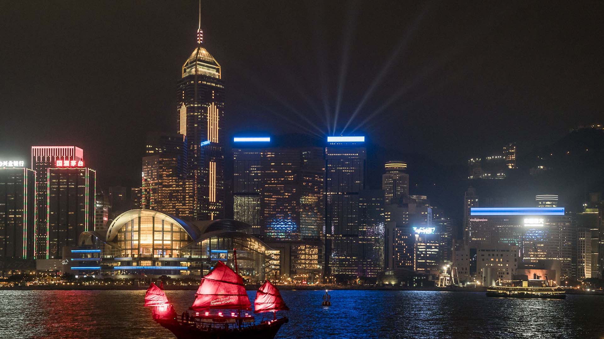 中式帆船载着旅客，在夜色下畅游维港。