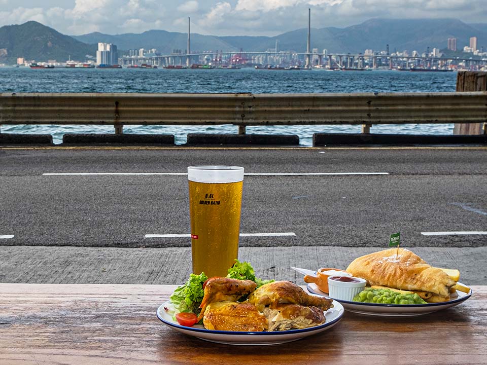 顾客可面对海景，品尝Fish & Chick的招牌法式烤鸡和啤酒。