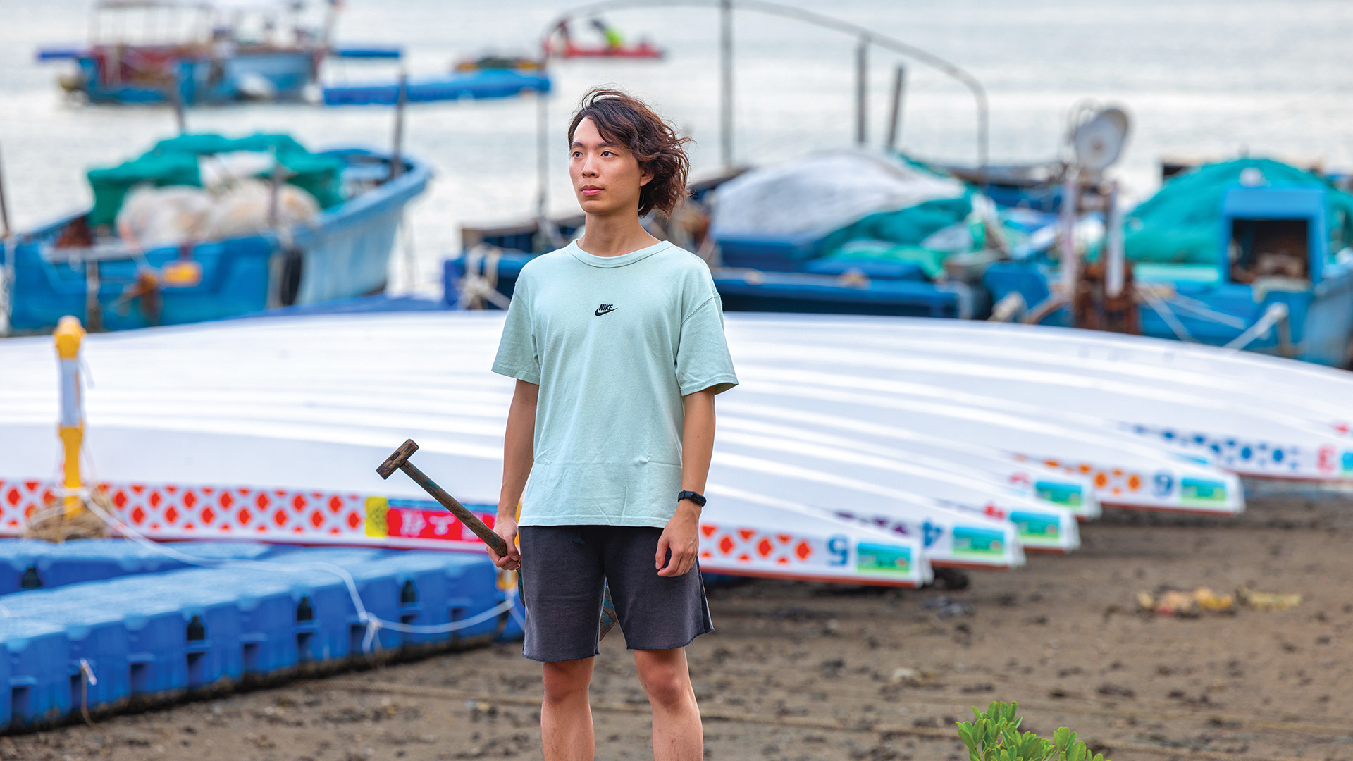 站在龙舟前的吴启谦