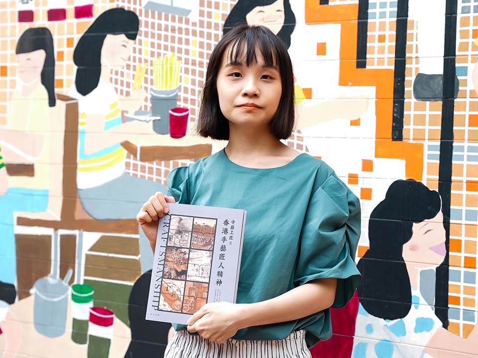 Rain在美都餐室的壁画前拿着自己的书